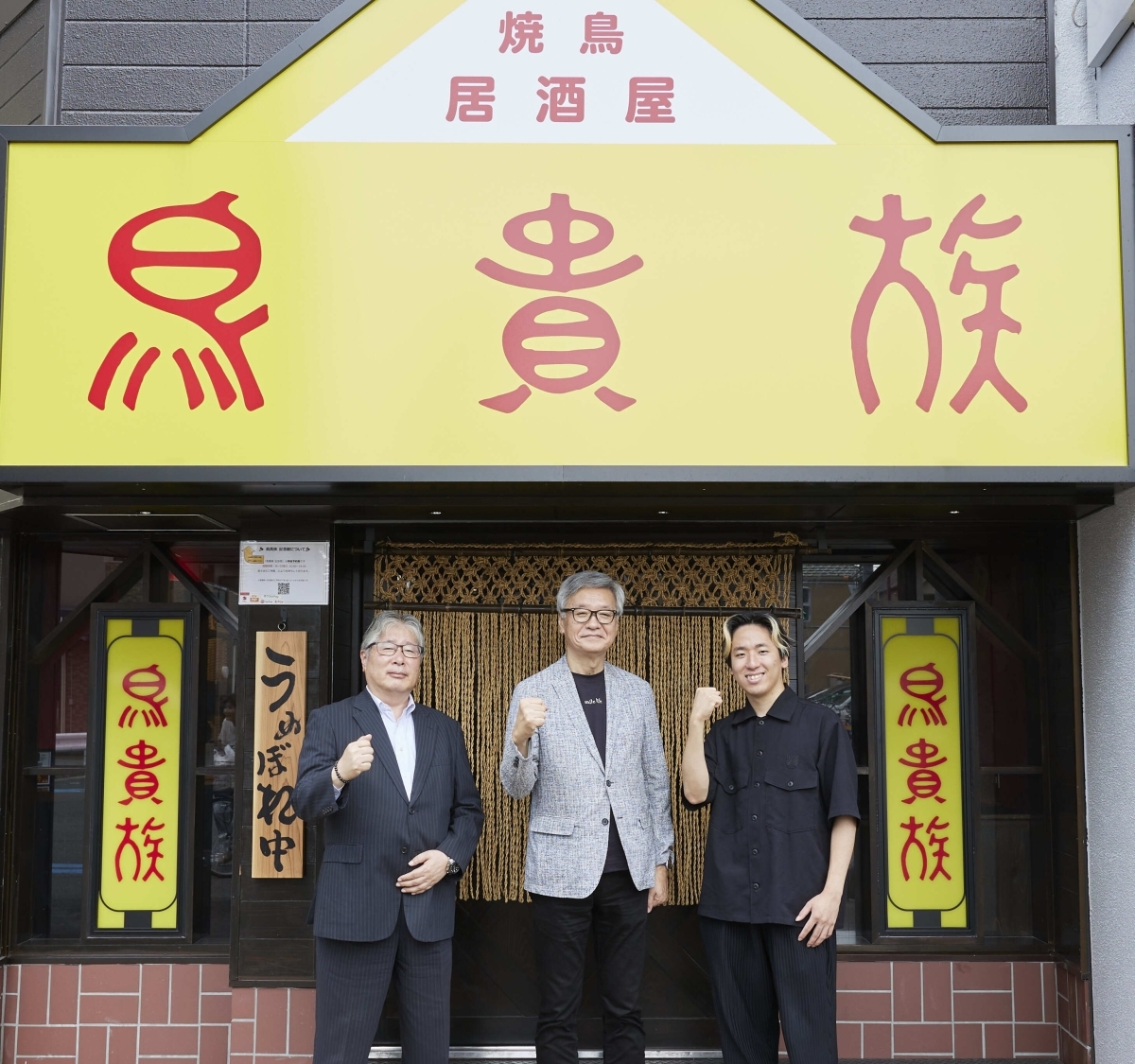 鳥貴族の店前に並んだ大倉忠司さんと青木繁則さん、西奈槻さん