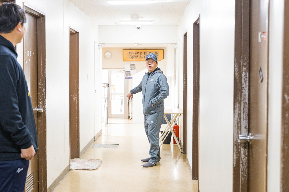 廊下に立つ藤井コーチ