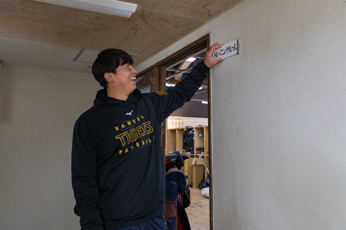 「トレーニングルーム」のプレートを持つ畠選手