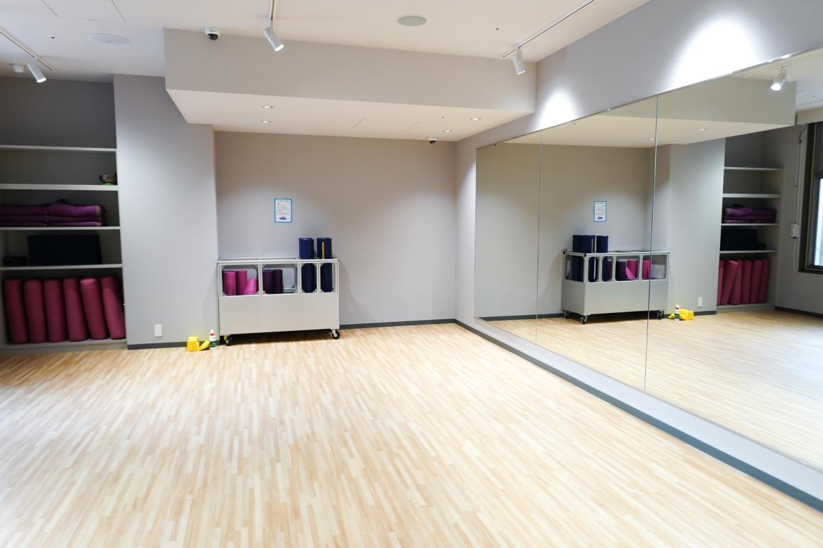 新設したスタジオの様子。床はきれいな白木目調。大型の壁面鏡が設置され、棚にはヨガマットが格納されています。
