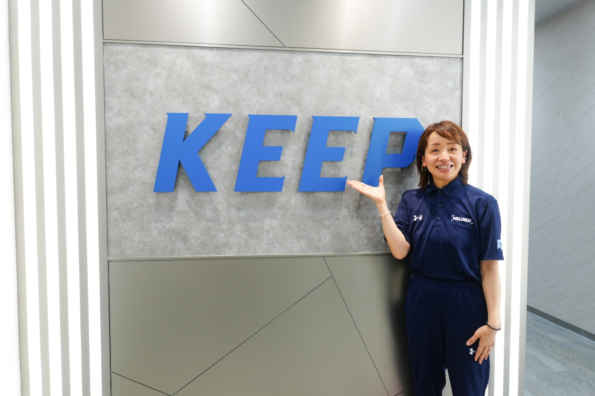 KEEPの看板前に立つ続木さんの写真