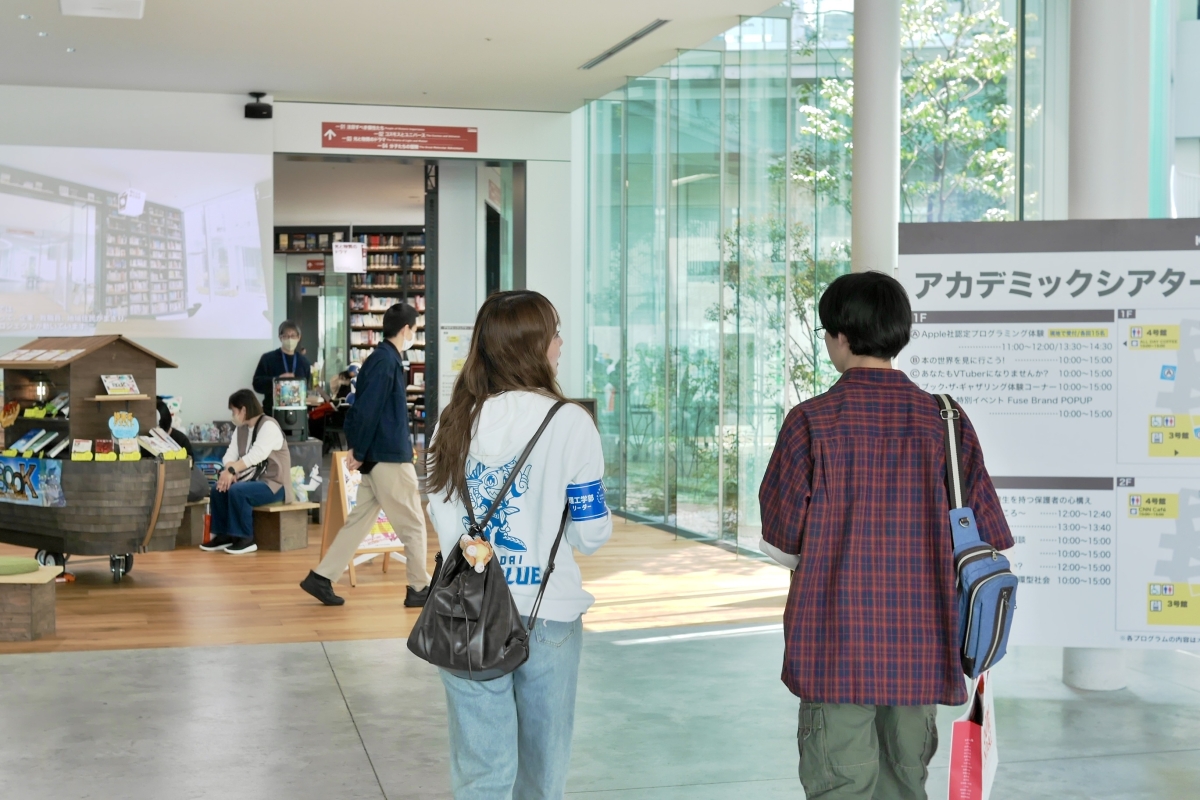 西陽捺さんが来場者を案内する後ろ姿