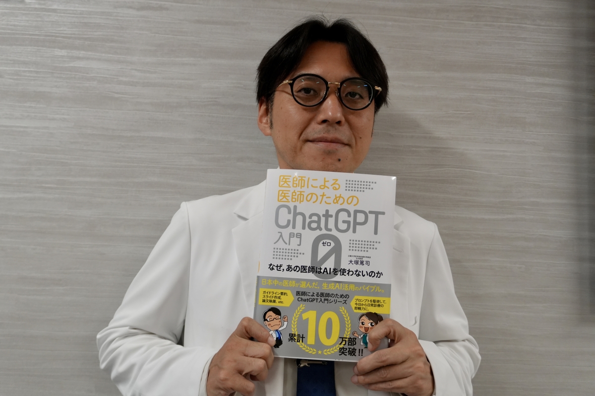 著書を手に持った大塚教授の写真